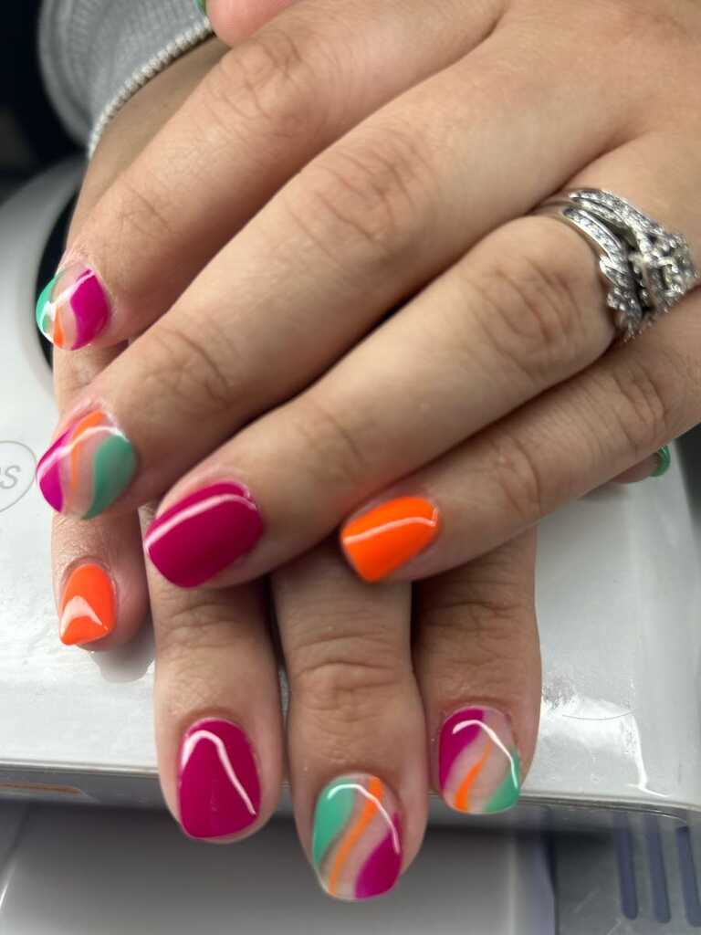 Short nails in a multicolour swirl of pink, orange, teal and white