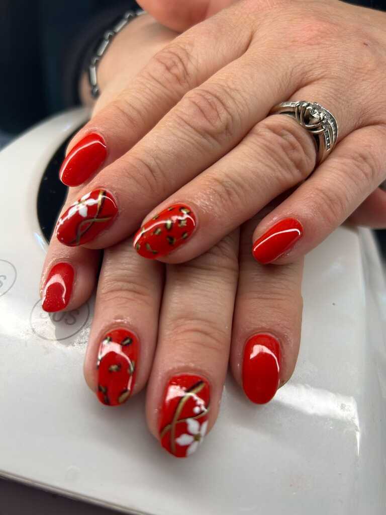 Bright red nails with hand-painted white cherry blossom and gold vines