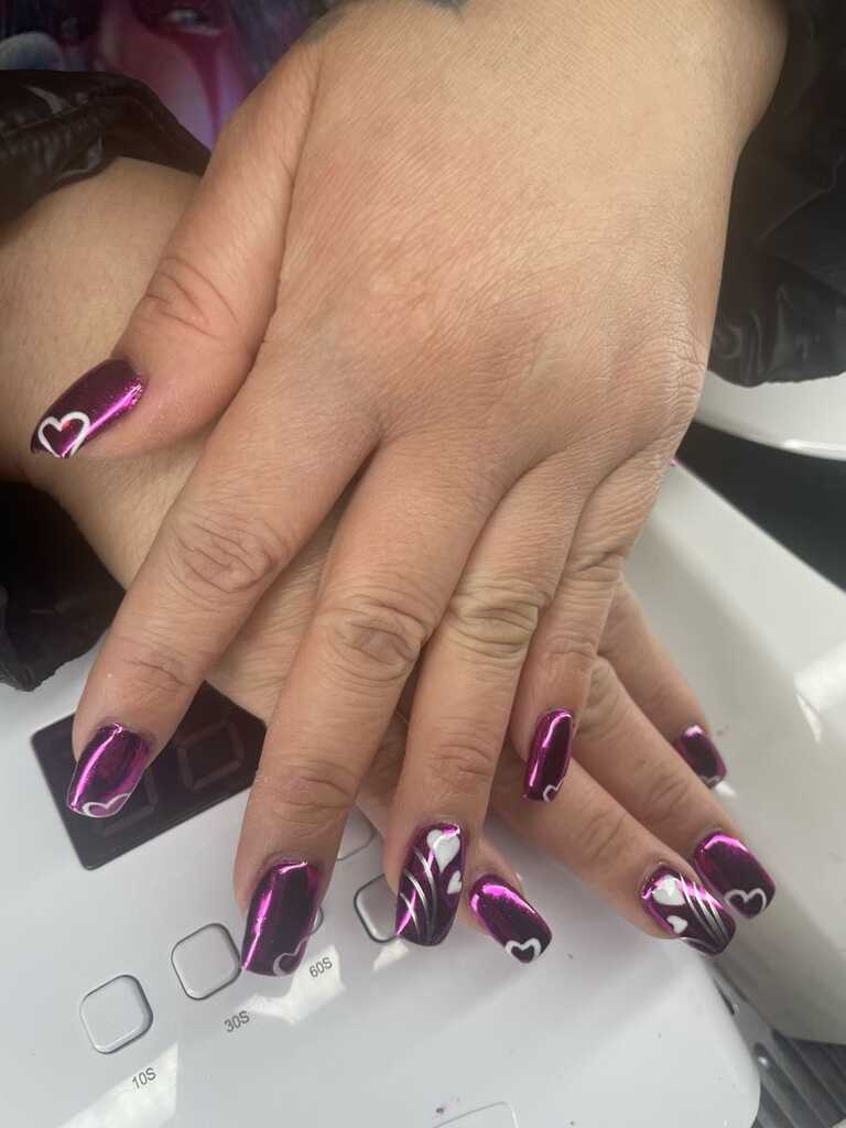 Magenta chrome nails with white hearts and swirl detailing